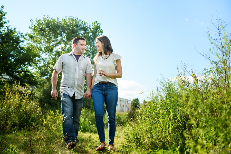 A man and woman walk through an abandoned lot in fishtown for their engagement session.